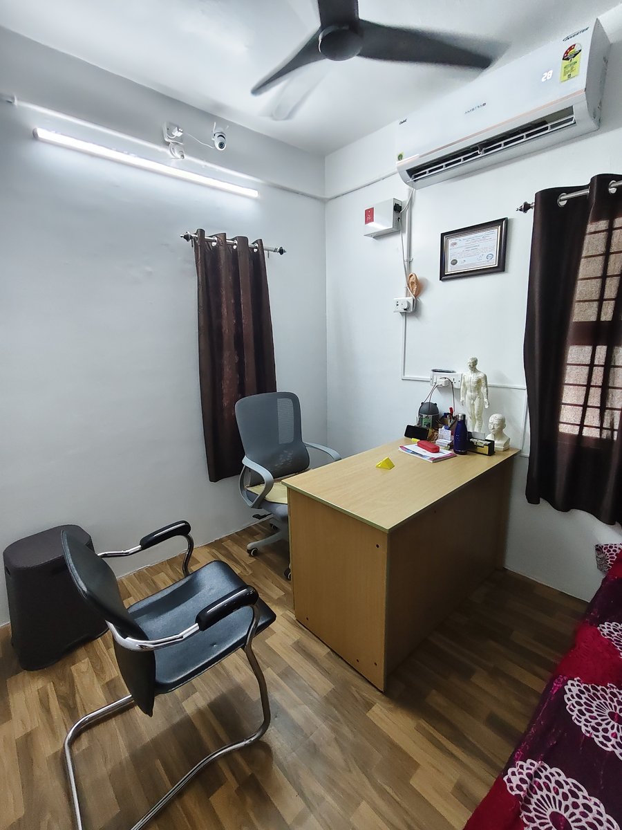 Doctor's consultation suite with classical acupuncture meridian models and patient seating