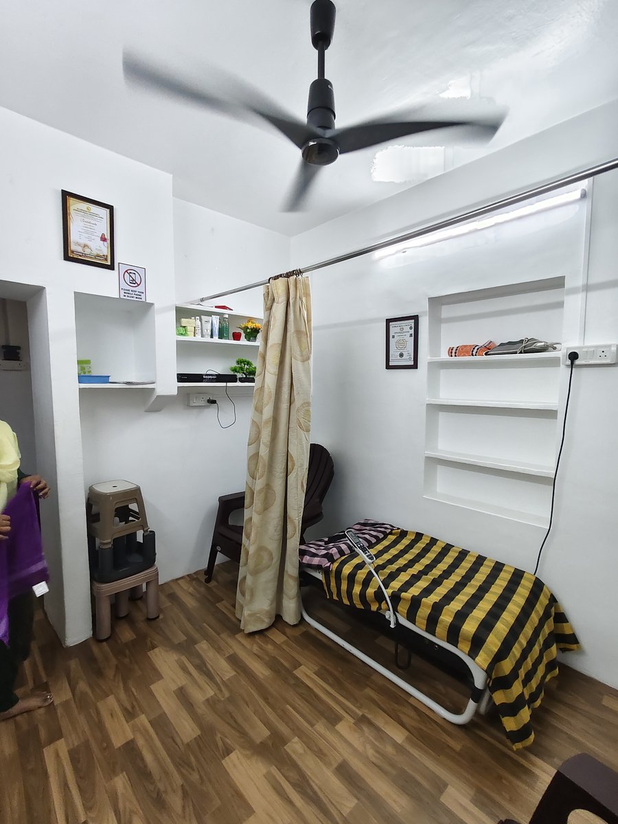 Private curtained treatment cubicles with hygienic therapy beds and reflexology charts